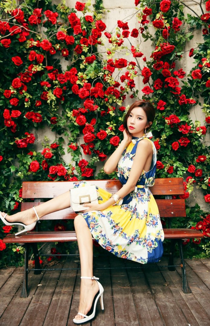 玫瑰花圃里的清新靓丽美模坐在长椅上显青春活力